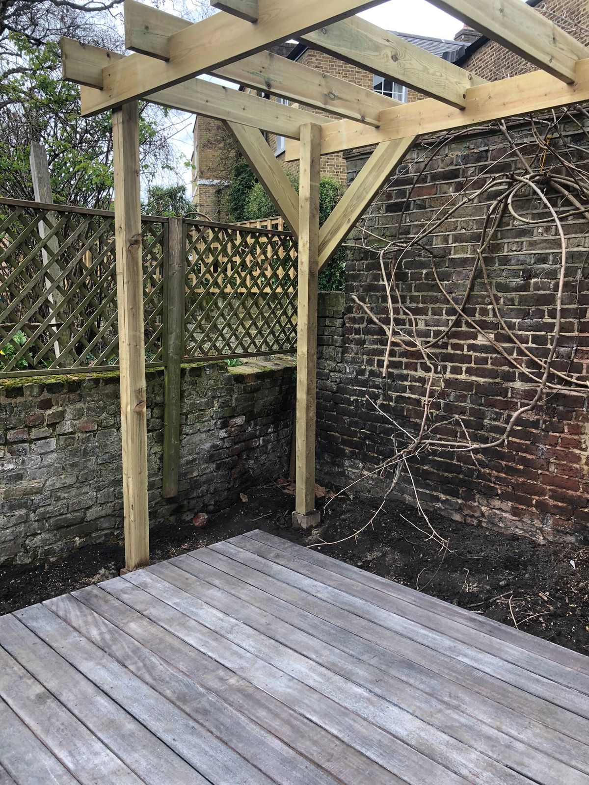 Pergola Installation Contrasting with Darkened Shou Sugi Ban Deck in Canonbury North London Garden