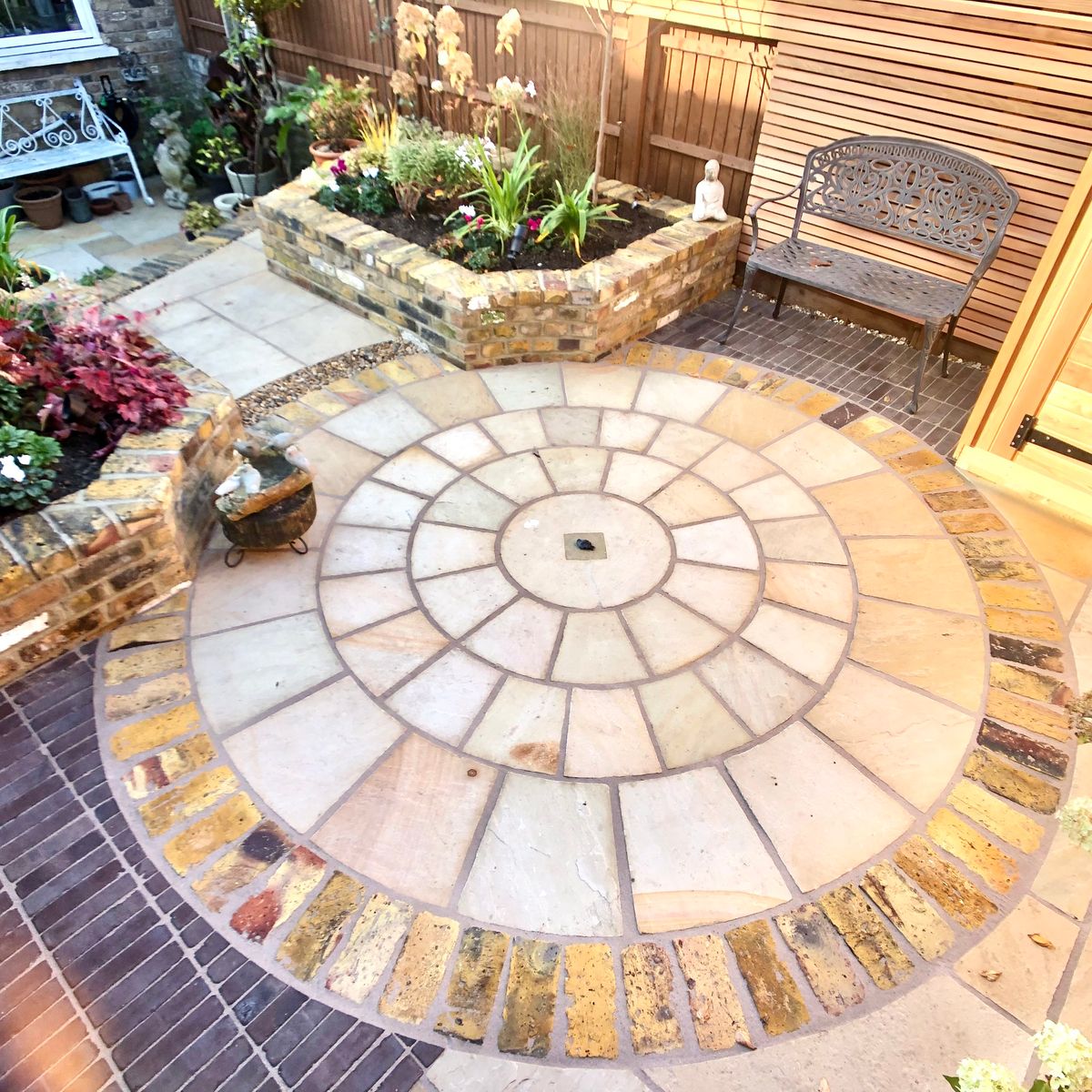 Detail of Circular Sandstone Paving and Brick Planters as part of Beautiful Small Garden Design in Dalston North London